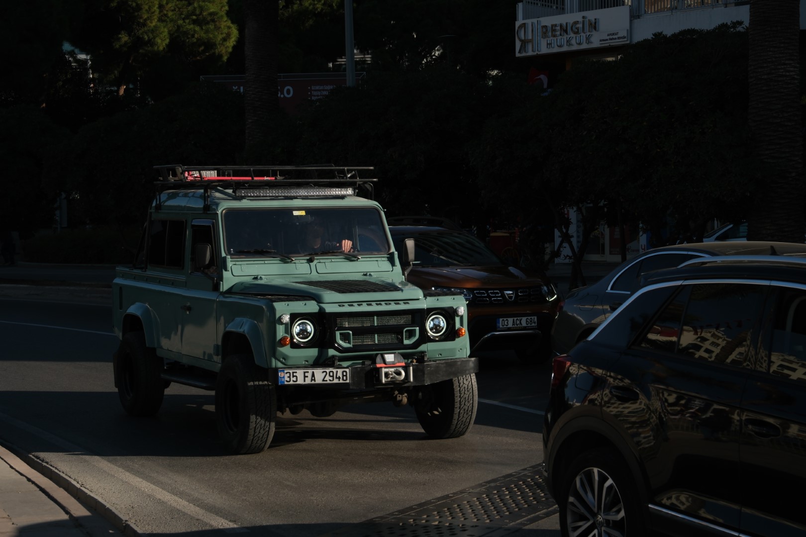 blue land rover defender 110 in a stoplight