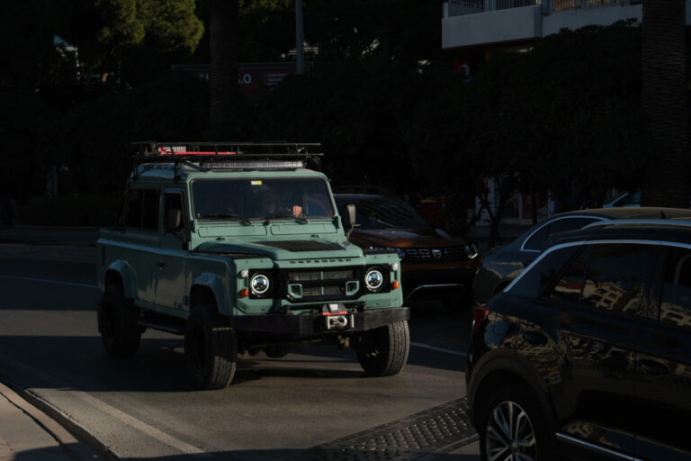 restored vintage land rover defender 110 in traffic