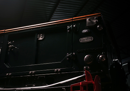 british racing green land rover defender 110 rearview
