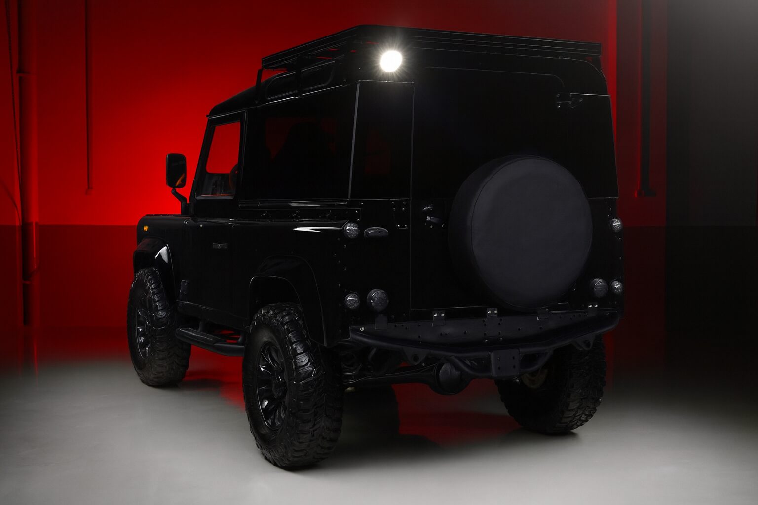 V8 Defender 90 Metallic Black with Red Background